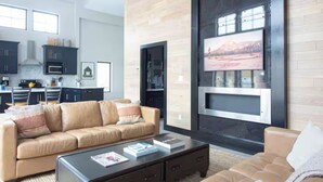 Un salon moderne avec un canapé beige, une table basse et une cheminée.