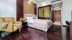 Una habitación de hotel con cama, sofá, mesita de noche y armario.
