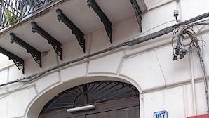 A building entrance with a wooden door, a metal balcony, and a number sign '167'. - Mille Lire B&B  (Palermo)