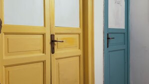 Two doors, one yellow and one blue, with a security camera above the blue door. - Mille Lire B&B  (Palermo)