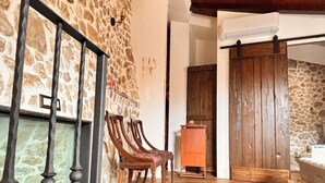 A rustic interior with stone walls, wooden flooring, and a wooden chair. - LA CASA DI NORIS (Fiuggi)