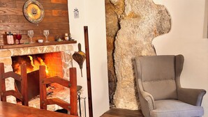 A cozy living room with a fireplace, wooden furniture, and a stone accent wall. - LA CASA DI NORIS (Fiuggi)