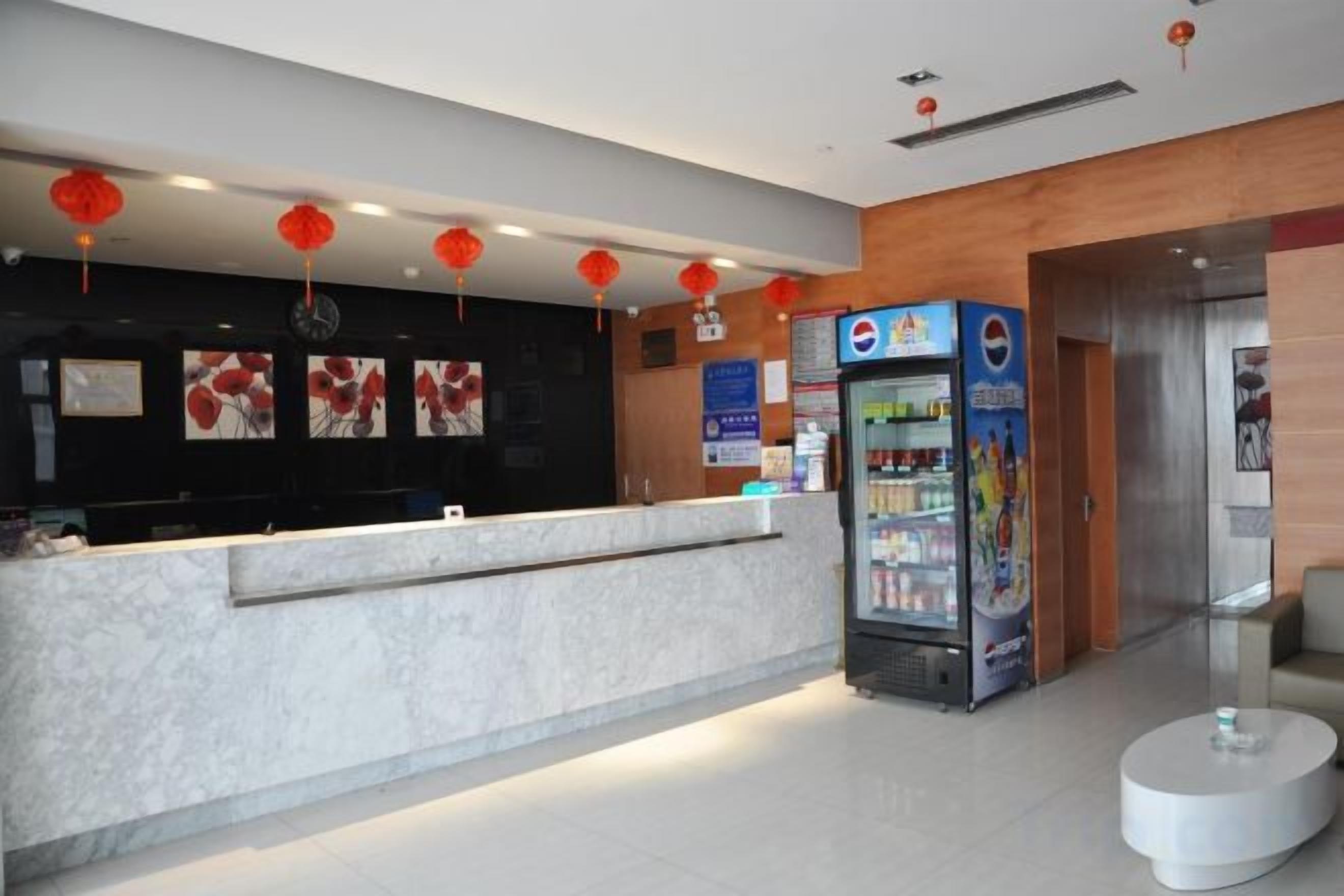 A hotel reception area with a marble counter, vending machines, and a wall with artwork.