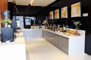 A modern kitchen with a central island, stainless steel appliances, and artwork on the walls.