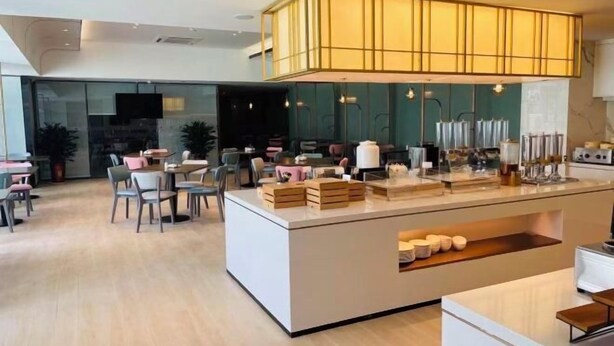 A modern hotel lobby with a central reception desk, seating area, and a large chandelier. - Yongle Star Hotel (Shiyan Fang County) (Fang County)
