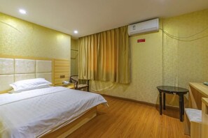 A hotel room with a bed, a chair, a small table, and an air conditioning unit. - Guangzhou Business Hotel (Shangxiajiu Pedestrian Street Changshou Road Subway Station Branch) (Guangzhou)