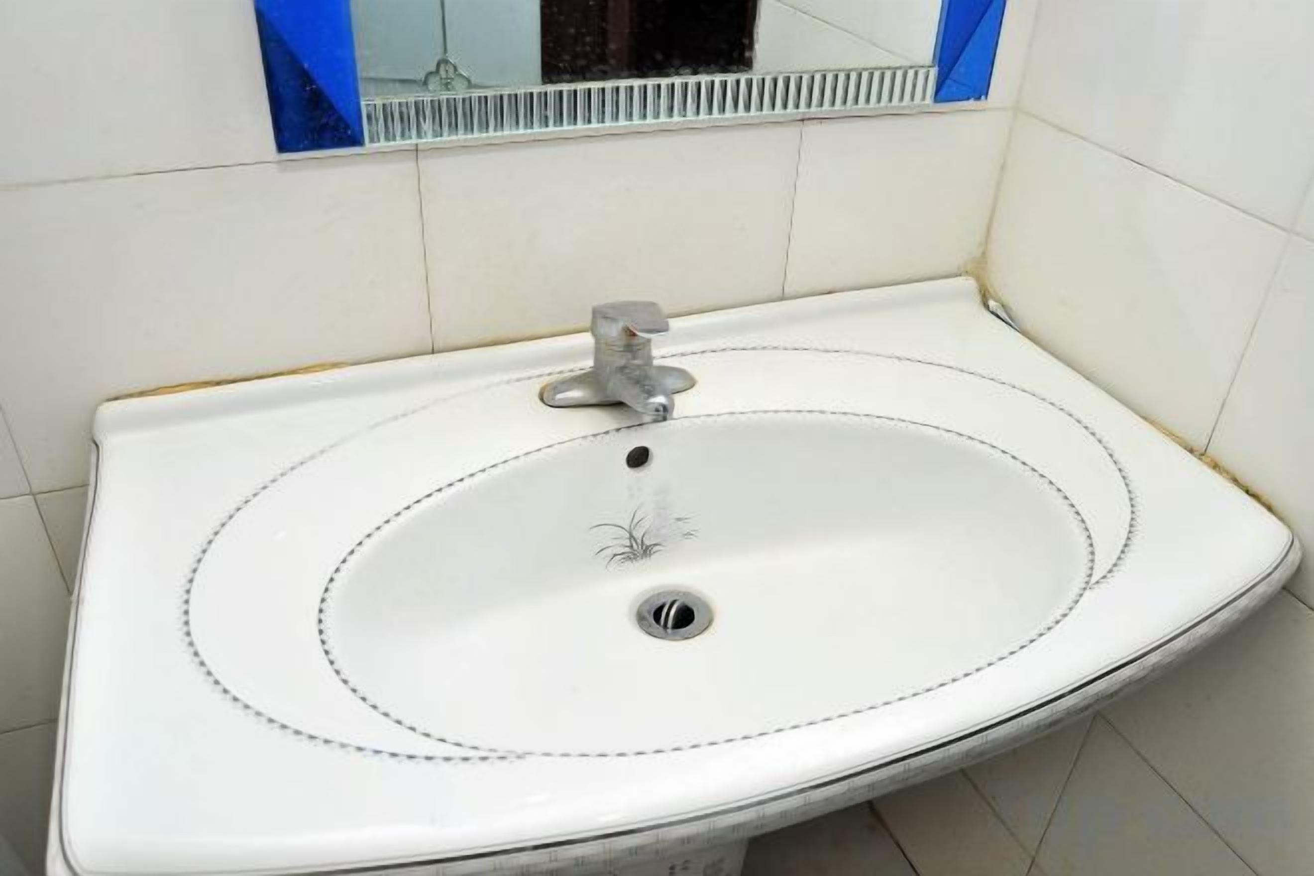 Un lavabo blanc avec un seul robinet dans une salle de bain.