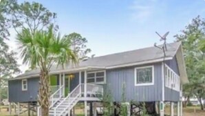 A two-story house with a porch, a staircase, and a satellite dish.