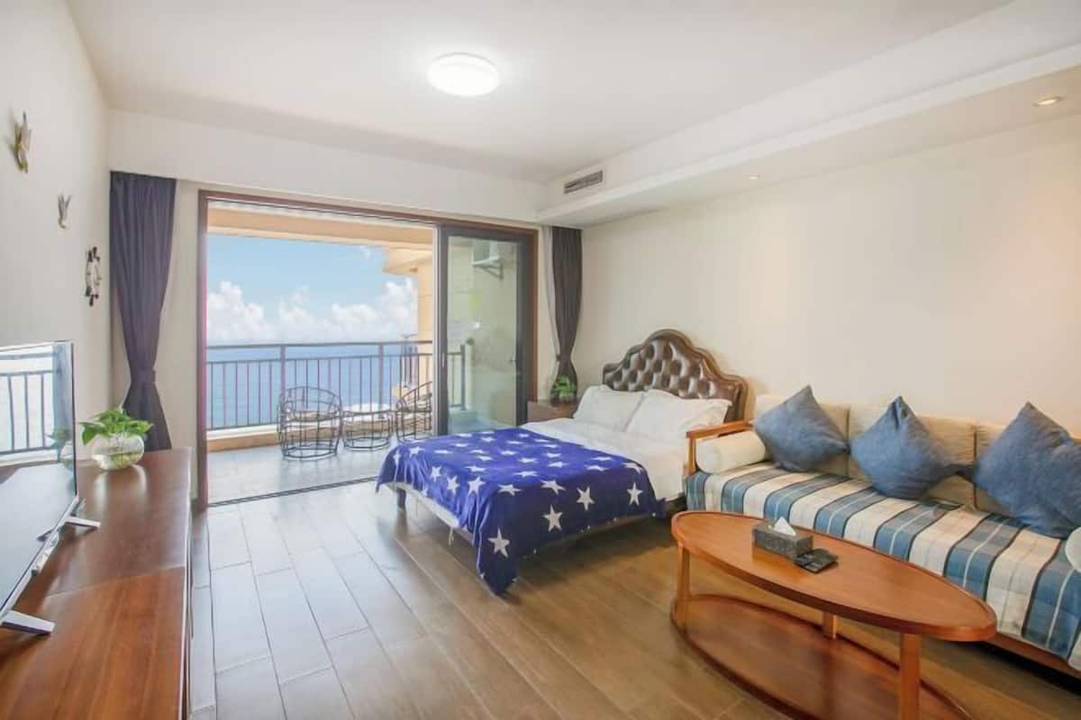 Une chambre d’hôtel avec un lit, un canapé, une table basse et un balcon avec vue.