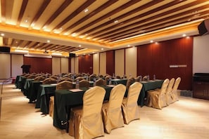 A conference room with rows of tables and chairs, a podium, and a stage. - Huizhou Shuangyuewan Yujian Haijing Dujia Gongyu (Huidong)