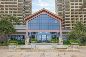 A modern building with a prominent entrance, large glass windows, and a symmetrical facade. - Huizhou Shuangyuewan Yujian Haijing Dujia Gongyu (Huidong)