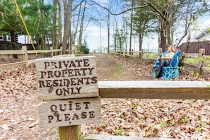 A wooden sign with "PRIVATE PROPERTY RESIDENTS ONLY" and "QUIET PLEASE" written on it.