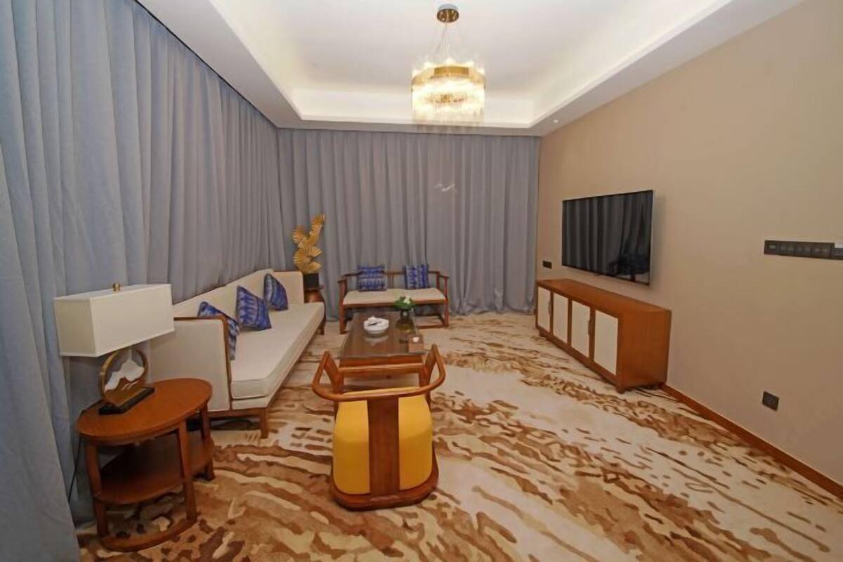 Uma sala de estar moderna com sofá, mesa de centro e televisão.