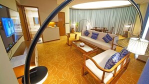 A hotel room with a sofa, armchairs, a coffee table, a TV, and a dining area with a table and chairs. - Chaozhou Taian Tang Ruiting Western Suburb Hot Spring Hotel (Chaozhou)
