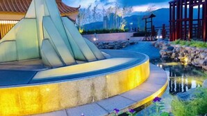 A landscaped area with a water feature, stone steps, and a wooden structure. - Chaozhou Taian Tang Ruiting Western Suburb Hot Spring Hotel (Chaozhou)