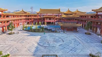 A courtyard with traditional architecture, a central water feature, and a patterned ground.