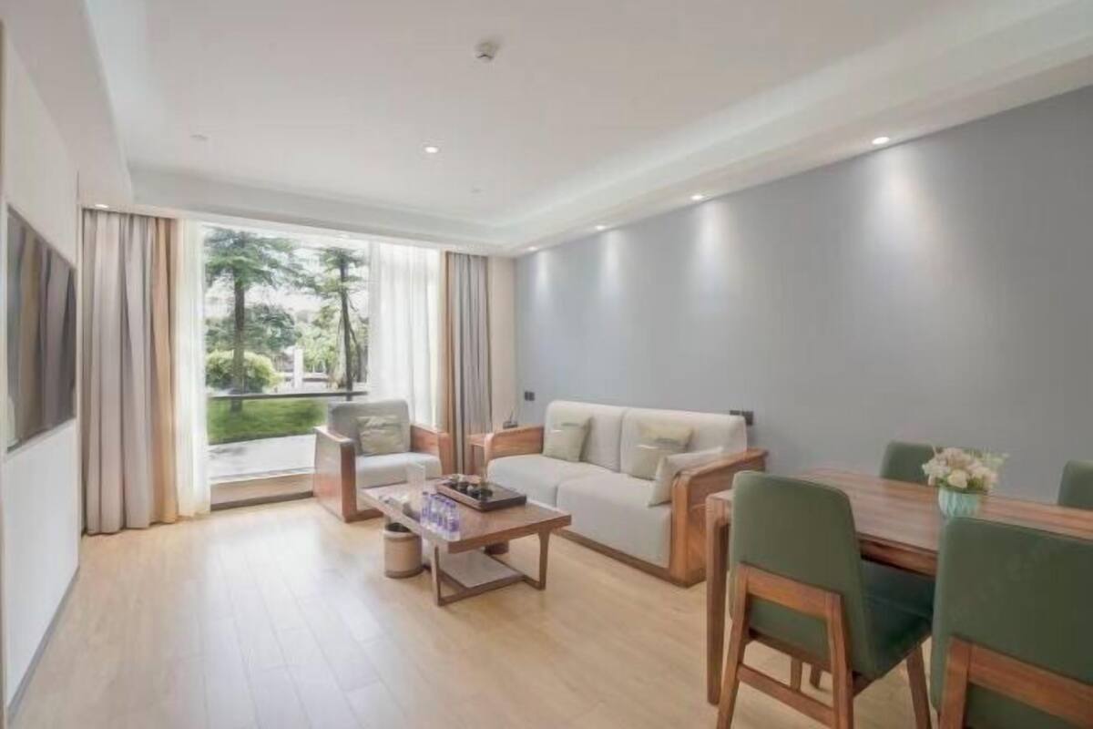 Uma sala de estar moderna com um sofá, mesa de centro e mesa de jantar.