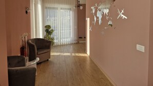 A room with a large window, a world map on the wall, a chair, and a small table. - 3-bedroom apartment in gorgeous Dizzasco with WiFi (Dizzasco)