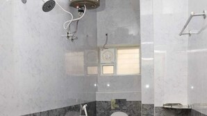Un baño moderno con inodoro, ducha y secador de manos.