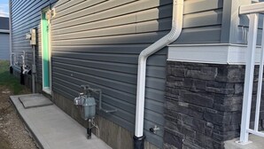 A building with horizontal siding and a stone foundation.