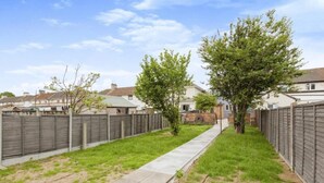 A residential backyard with a wooden fence, a concrete pathway, and a small tree. - 3 Bedroom House- Loughborough-sleeps 5-freeparking (Loughborough)