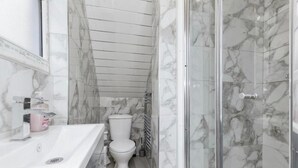 A bathroom with a white sink, toilet, and a glass shower enclosure. - 3 Bedroom House- Loughborough-sleeps 5-freeparking (Loughborough)
