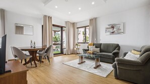 A modern living room with a dining area, a sofa set, a coffee table, and a TV. - Summertime Stay by Homie (Funchal)