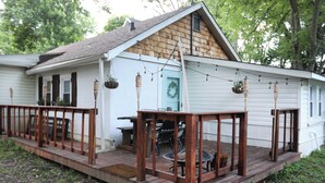 A small white house with a wooden deck and a covered patio area. - Charming 2-bedroom cottage 10 min to downtown - King bed - Fireplace (Nashville)