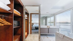 Un baño moderno con una bañera grande, una ducha a ras de suelo y vistas al agua.