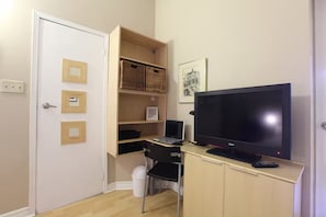 Cozy retreat with a television, desk, and comfortable chair.