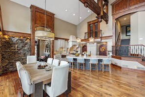 Enjoy cooking and dining in this elegantly designed space with a large dining table, comfortable chairs, and a modern kitchen with ample workspace.