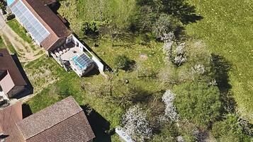 An aerial view of a residential area with houses, a swimming pool, and a field.