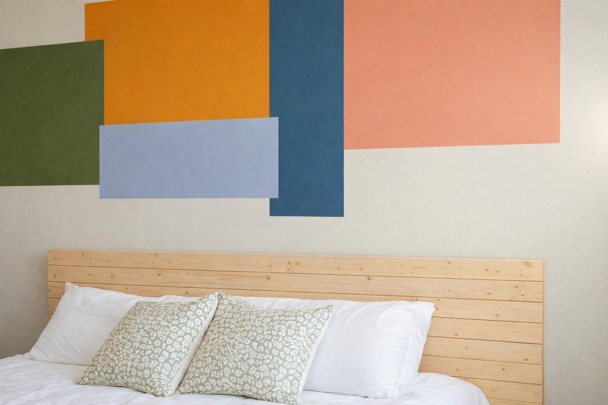 A bed with a wooden headboard, white bedding, and patterned pillows.