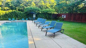 Una piscina amb gandules i una tanca de fusta al fons.