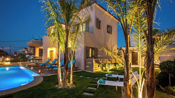 A modern villa with a swimming pool, outdoor seating, and a well-maintained garden.