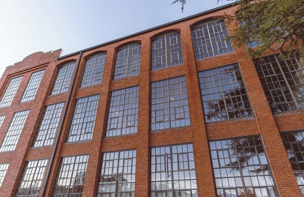 Un edificio de varios pisos con grandes ventanales y fachada de ladrillo.