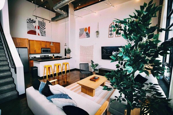 A modern living space with a kitchen, dining area, and seating area. - Cozy mill loft w/ 2 king beds, gym & pool (Spartanburg)