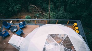 Una terraza con mobiliario exterior y una gran estructura tipo carpa.