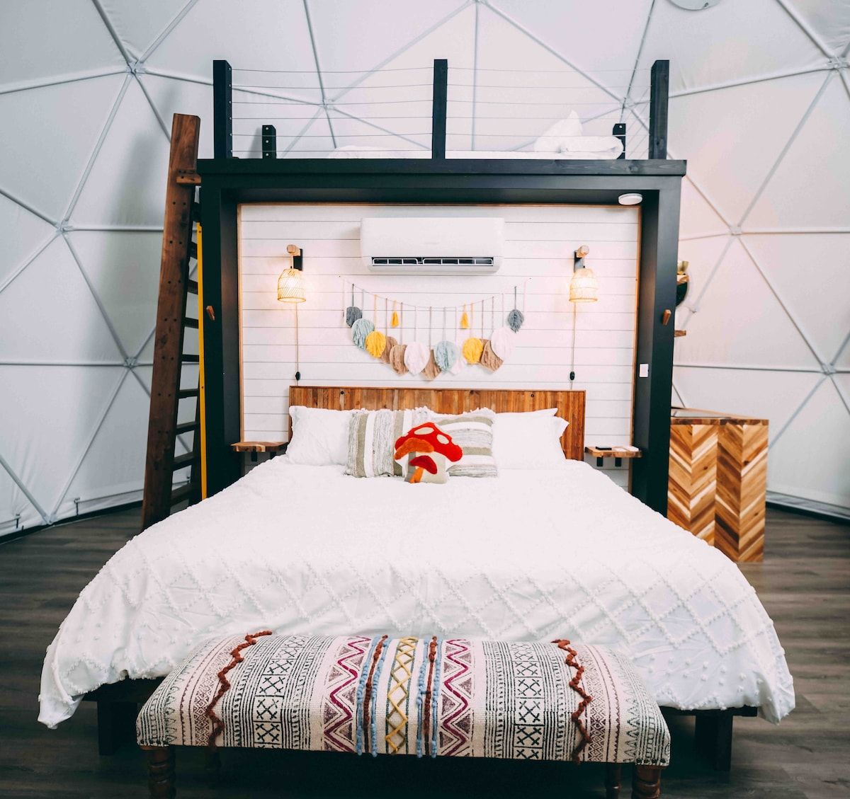 A modern bedroom with a wooden headboard, a white bedspread, and a decorative pillow.