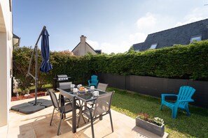 A patio with a table, chairs, and a grill. - Ti Cosy - 7min de la Plage (Fréhel)