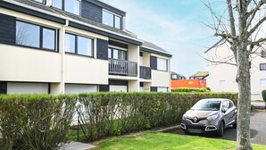 Een modern woonhuis met twee verdiepingen en een auto op de oprit.