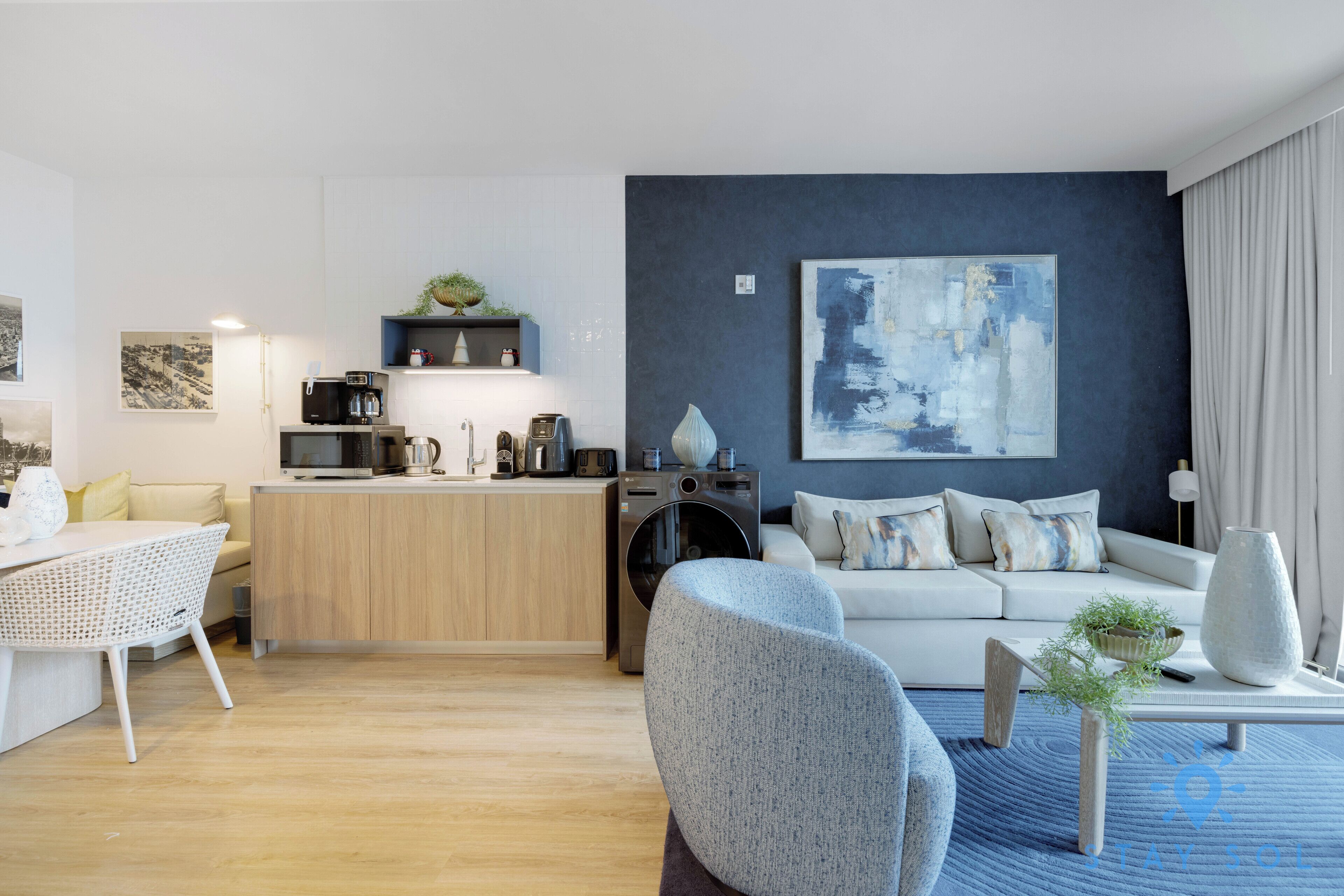 A modern living room with a sofa, coffee table, and a painting on the wall.