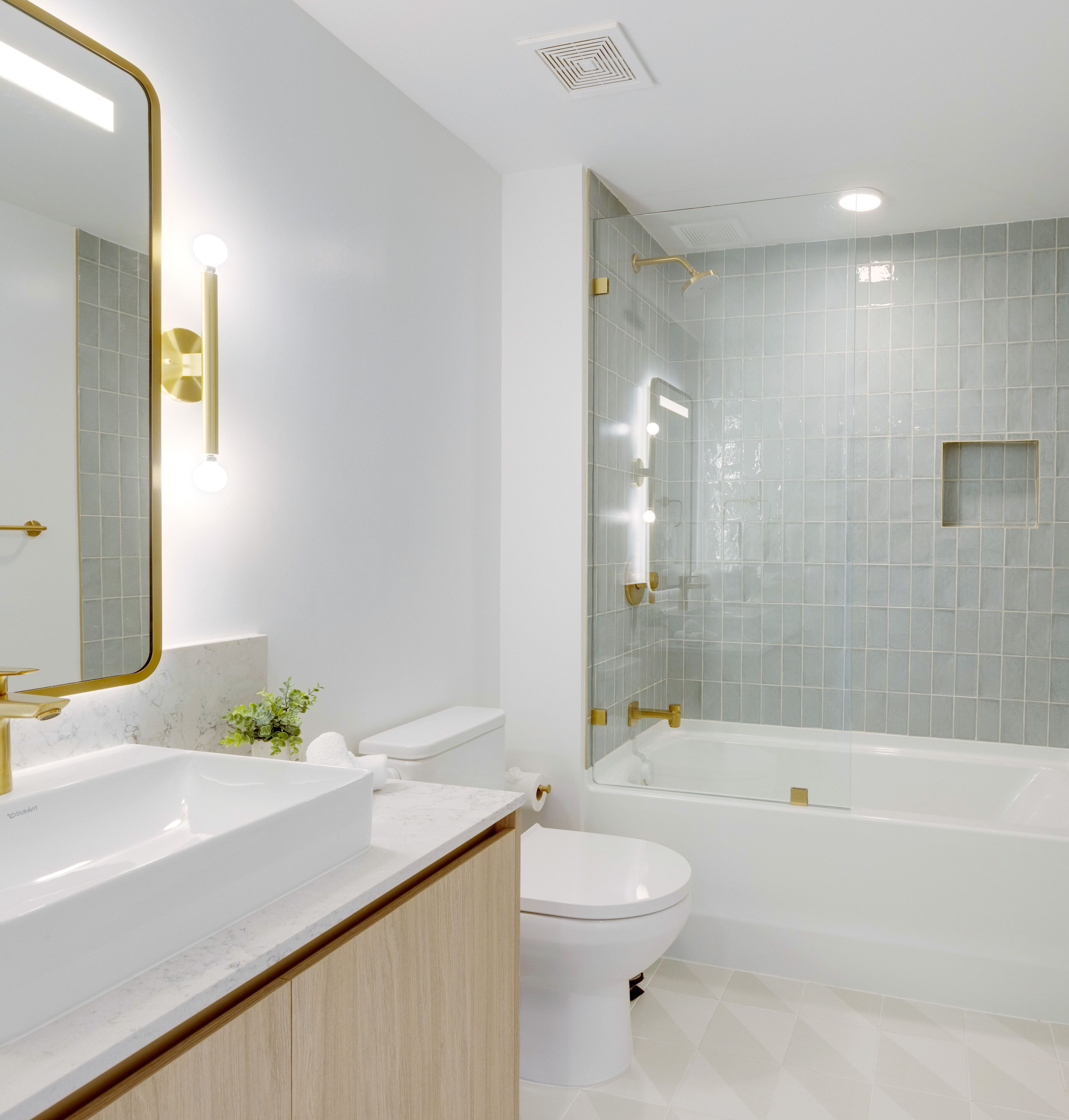 Une salle de bain moderne avec un lavabo, des toilettes et une baignoire, le tout de couleur blanche.