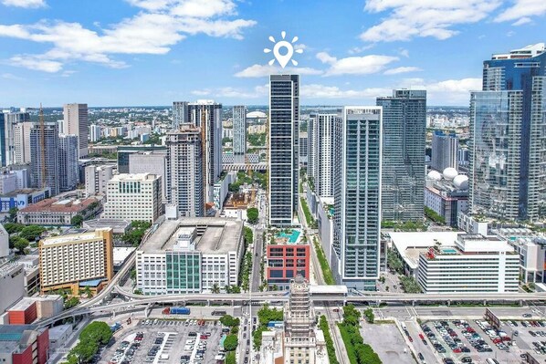 A cityscape with modern high-rise buildings, a parking lot, and a clear sky. - Stay Sol Downtown (Miami)