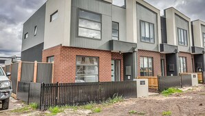 A modern multi-story residential building with a brick facade and large windows. - StayAU Fresh Modern 5BR Retreat Netflix in Berwick (Berwick)