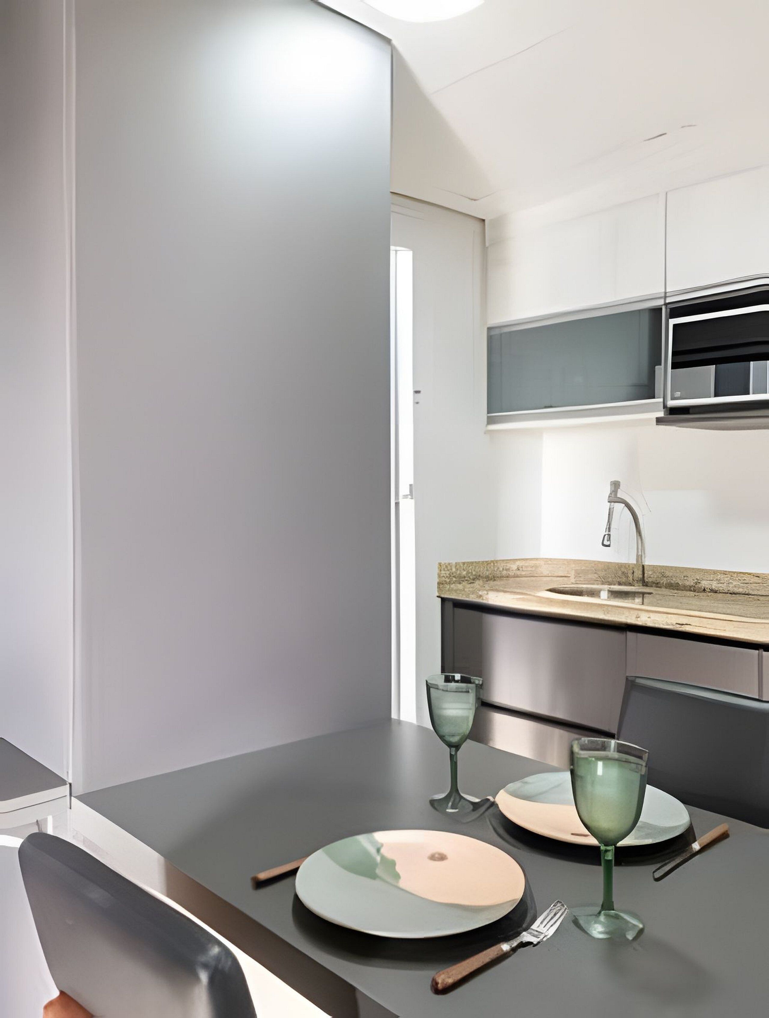 A modern kitchen with a built-in oven, a sink, and a window above the countertop.