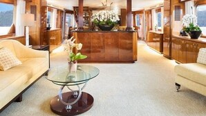 Un interior lujoso con un mostrador de recepción central, dos sofás, una mesa de centro de cristal y plantas decorativas.