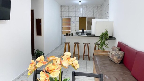 A compact living space with a dining area, kitchen, and seating area. - Condomínio Gelatti (Ubatuba)