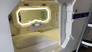 A futuristic room with a bed, a control panel, and a digital display. - Blue Hostel Bláu Fjöll (Vestmannaeyjar)