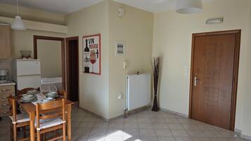 A spacious kitchen with a dining table set for four, a refrigerator, and a radiator.